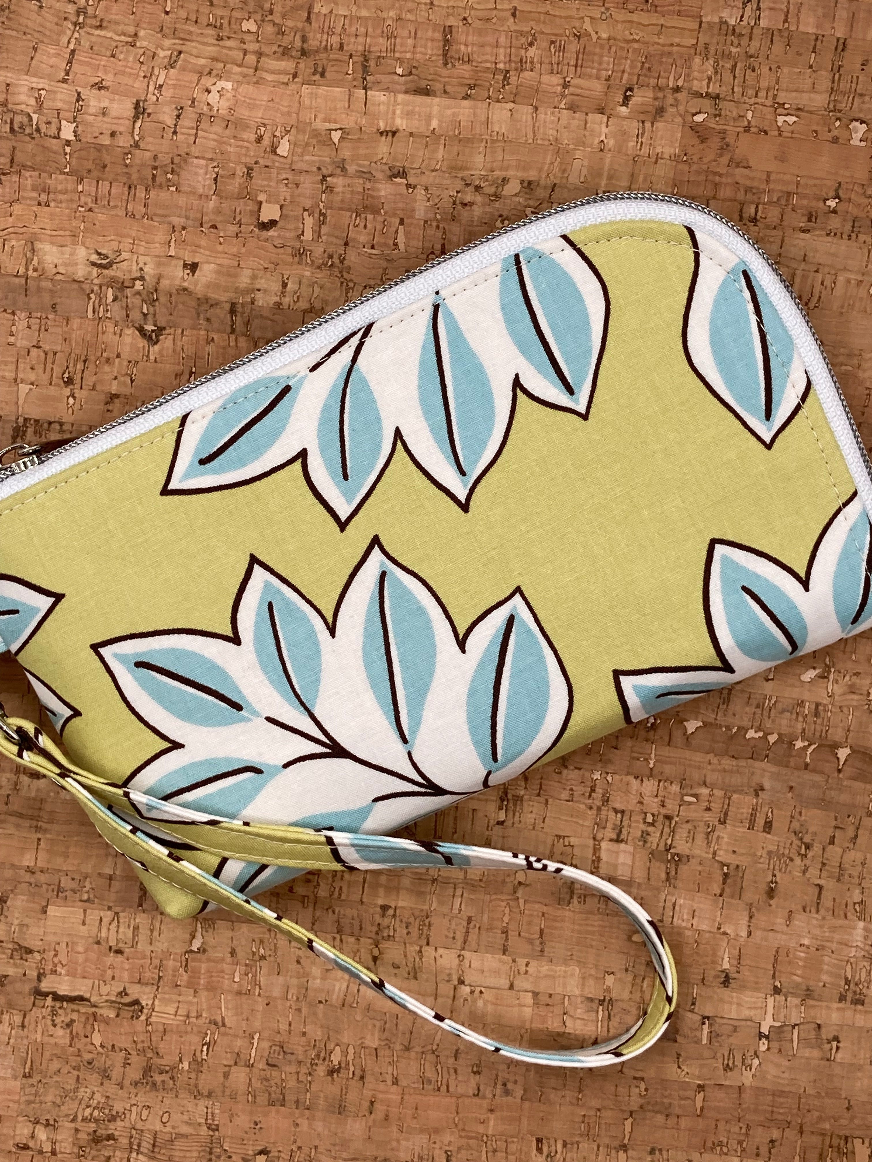 Blue leaf on a lime green background cotton fabric exterior with white nickel nylon zipper wristlet